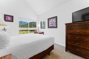 1 dormitorio con 1 cama y vestidor con TV de pantalla plana en Greens at Copper 317 by Summit County Mountain Retreats, en Copper Mountain