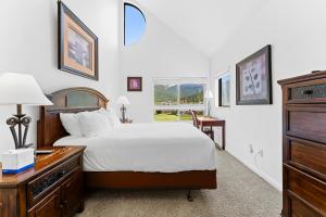 Un dormitorio con una cama y un escritorio y una ventana. en Greens at Copper 317 by Summit County Mountain Retreats, en Copper Mountain
