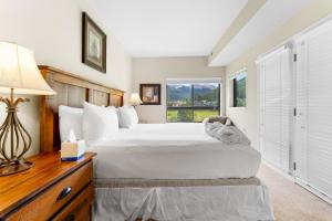 Un dormitorio con una cama grande y un escritorio con lámpara. en Greens at Copper 219 by Summit County Mountain Retreats, en Copper Mountain