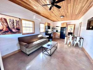 una sala de estar con un sofá y una mesa en Little Haus on the Farm with a Hot Tub, en Fredericksburg