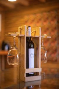 a bottle of wine in a wooden holder with two wine glasses at Cabaña con Jacuzzi en Santa Elena in Medellín +23 photos