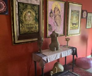 a table in a room with paintings on the wall at sunrise flats in Mellieħa
