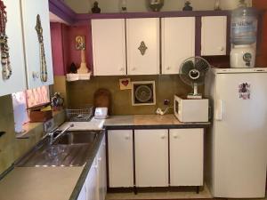 a kitchen with white cabinets and a sink and a refrigerator at sunrise flats in Mellieħa +11 photos