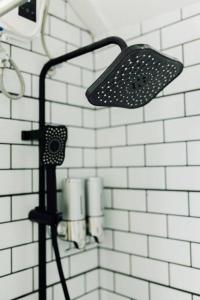 a shower with a light on a white tiled wall at Balikbayan hub in Cabanatuan in Cabanatuan