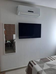 a bedroom with a flat screen tv on a wall at Manawa Beach Flat - Porto de Galinhas in Porto De Galinhas