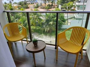 two chairs and a table on a balcony with a view at Manawa Beach Flat - Porto de Galinhas in Porto De Galinhas