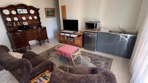 a living room with couches and a tv and a kitchen at Bult-Op1 in Bloemfontein