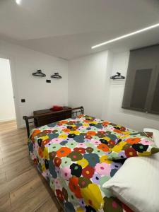 a bedroom with a bed with a colorful comforter at Vidanova 1 in Vilanova i la Geltrú