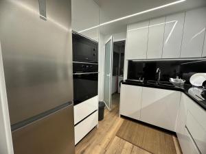 a kitchen with white cabinets and a stainless steel refrigerator at Vidanova 1 in Vilanova i la Geltrú