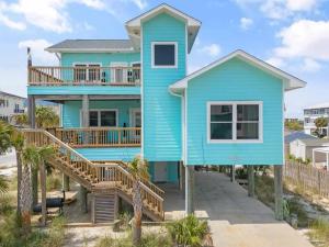 a blue house with a deck on the beach at Blue Horizon at Pensacola Beach - Heated Pool, Across beach access, Beach gear, Dogs OK! in Pensacola Beach