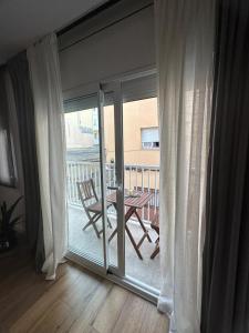 a sliding glass door with a table and a balcony at Vidanova 1 in Vilanova i la Geltrú