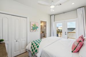 a bedroom with a white bed and a sliding glass door at Blue Horizon at Pensacola Beach - Heated Pool, Across beach access, Beach gear, Dogs OK! in Pensacola Beach +43 photos
