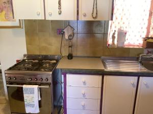 a kitchen with a stove and white cabinets at sunrise flats in Mellieħa