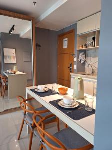 a dining room table with two chairs and a kitchen at JADE - Flat Particular in Brasilia