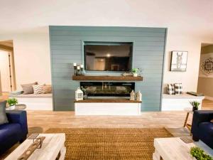 sala de estar con pared azul y TV en The Phoenix Farmhouse, en Phoenix