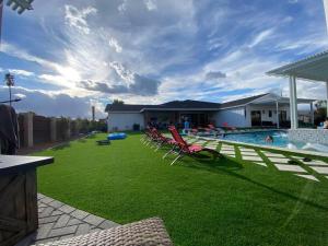 un patio con sillas de césped y una piscina en The Phoenix Farmhouse, en Phoenix