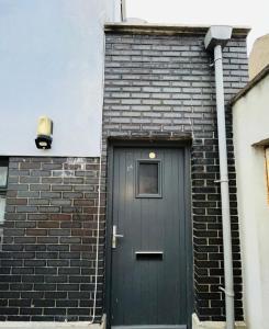 a black door on the side of a brick building at Casa acogedora en D08 in Dublin