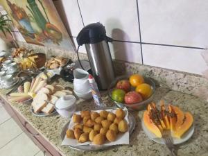 a counter topped with plates of fruit on a table at Quartos na Montanha in Siderópolis