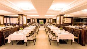 a dining room with tables with white tablecloths at Kubitschek Plaza Hotel - Flat Particular 4 - ALM Hospedagens in Brasília
