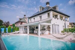 a large house with a swimming pool in front of it at B&B LUXURY ITALIAN HOUSE in Rho
