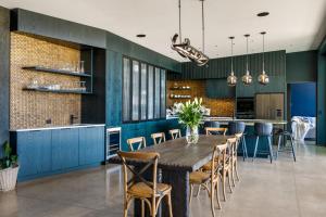 a dining room and kitchen with a wooden table and chairs at Riverbank by Sothebys Luxury Rental Homes in Wanaka