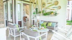 ラス・テレナスにあるVillas Maranata Complex 5 Villas 3Brd FrontBeachのソファ、テーブル、椅子付きのポーチ