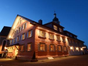 ein großes Gebäude mit Lichtern in der Nacht in der Unterkunft Zum Hirschen - hotel & gasthaus beim stöckeler in Scheidegg
