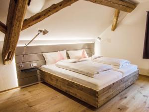a large bed in a room with a lamp at Zum Hirschen - hotel & gasthaus beim stöckeler in Scheidegg