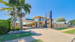 un edificio con una palma di fronte di Emerald Central Palms Motel a Emerald