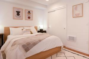 a bedroom with a large bed with white walls at Stunning Capitol Hill 1BD Condo in Seattle
