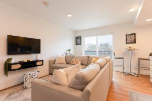 a living room with a couch and a flat screen tv at Stunning Capitol Hill 1BD Condo in Seattle