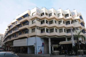 a large building on the corner of a street at Atrium Zenon Hotel Apartments in Larnaca