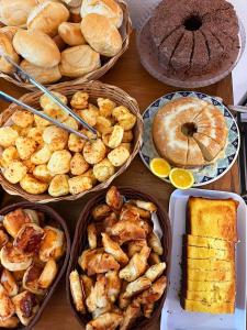 a table topped with different types of bread and pastries at Pouso Antônio d'Maria in Tiradentes