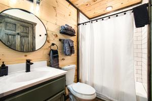 a bathroom with a toilet and a sink and a mirror at Hot Tub, Games, Fireplace & Fast WiFi Near Dollywood in Sevierville +84 photos