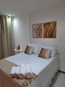 a bedroom with a large white bed with towels on it at Apto 19º andar, piscina, academia, garagem, ao lado do Shopping Salvador in Salvador +41 photos