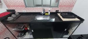 a kitchen counter with a sink and a stove at Kitnet para Férias in Massaguassu +6 photos