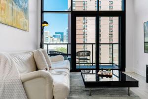 a living room with a white couch and a large window at City Views! Luxury King bed gym pool HTub in American Towers Condominium +46 photos