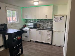 a kitchen with white cabinets and a white refrigerator at Lovely apartment house in Grimsby