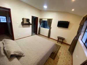 Finca la Magdalena ''Jacuzzi, naturaleza en la casona'' في Hacienda Conraquí: غرفة نوم مع سرير وتلفزيون بشاشة مسطحة