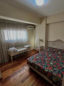 een slaapkamer met een bed, twee tafels en een raam bij Carriles Inn in Mendoza