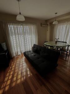 een woonkamer met een zwarte bank en een tafel bij Carriles Inn in Mendoza