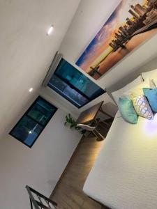 a living room with a bed and two windows at Casa Carolina Loft Aryaz in Tepoztlán