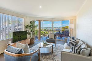 a living room with a couch and a tv at Baywatch 3 in Merimbula