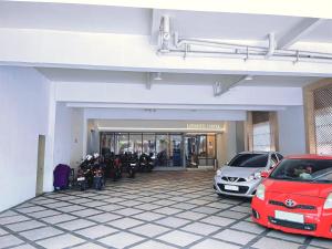 two cars parked in front of a garage at Laxston Hotel in Yogyakarta
