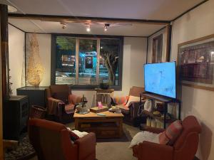 a living room with couches and a flat screen tv at Hostal Amerindia in Puerto Natales