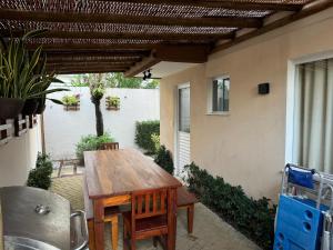 a wooden table in the patio of a house at GUARAJUBA -Porto Smeralda Térreo A001 in Camacari
