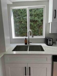 a kitchen with a sink and a window at Almost Home in West Vancouver