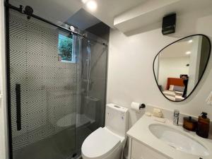 a bathroom with a shower and a toilet and a sink at Almost Home in West Vancouver +54 photos