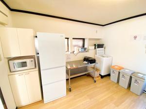 a kitchen with a refrigerator and a desk in a room at 最大5名様利用可 モダンでスタイリッシュなムーヴ戸田241 大型TV完備 wifiあり in Toda +23 photos