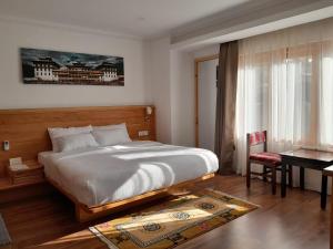 Voodi või voodid majutusasutuse Phuntsho Khangsar Hotel toas